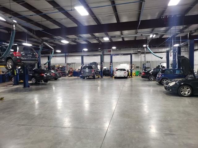 Wide view of the Turning Wrenches service bays with cars and SUVs on the lifts