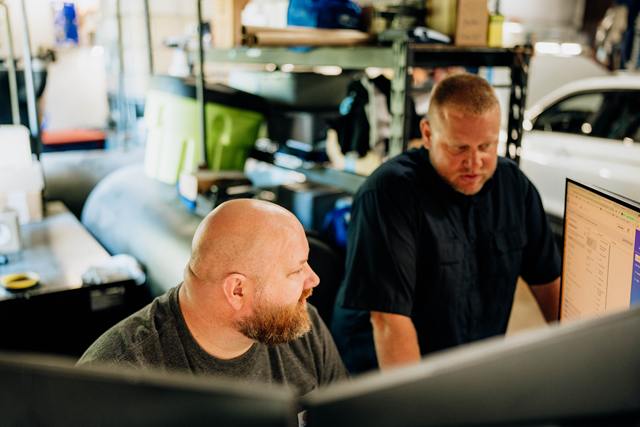 Service team reviewing a repair on the front desk computer