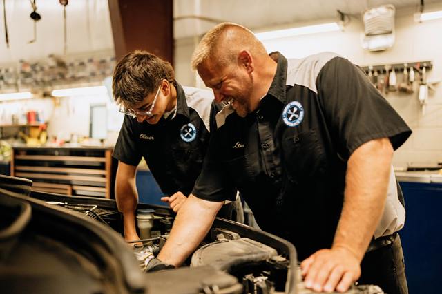 Owner Levi Johnson and a technician working together under the hood