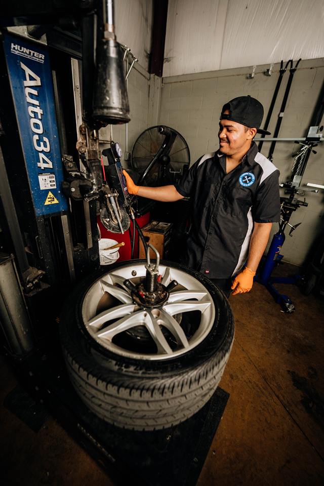 Technician mounting a tire on a Hunter Auto34 tire changer