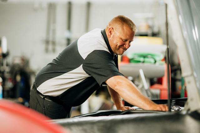 Technician leaning into an engine bay