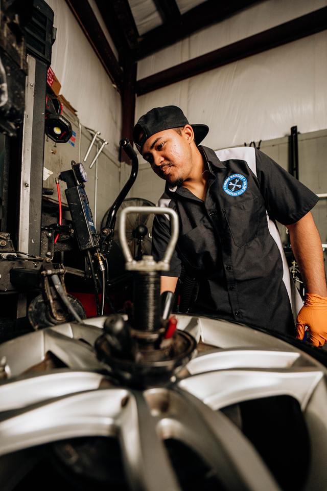 Technician working an alloy wheel on the tire changer